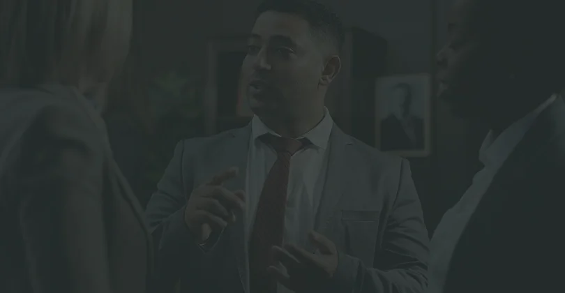 A man in a suit converses with another man, both engaged in a professional discussion.